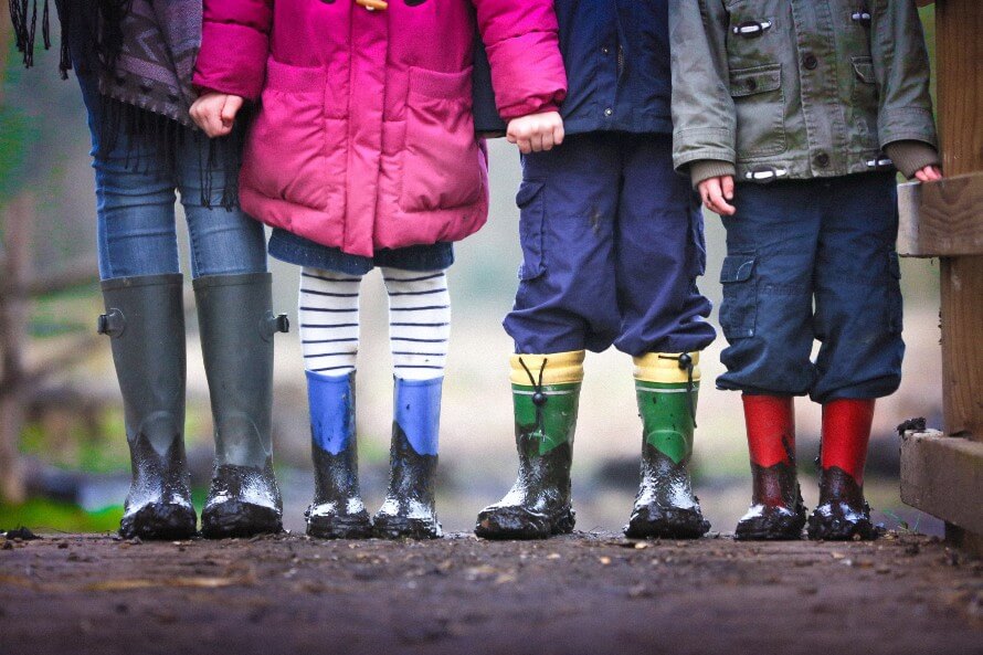 Picture of family from waist down, standing side by side, wearing rain gear 