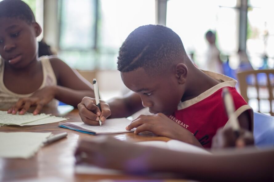 Two kids sitting at desk doing homework