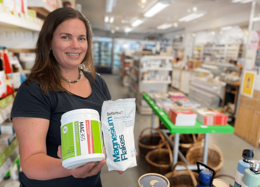Hannah inside Organico shop holding magnesium supplements. 