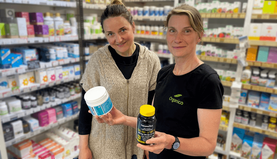 Sarune and Fleur standing in Organico. Fleur holds two bone health supplements. 