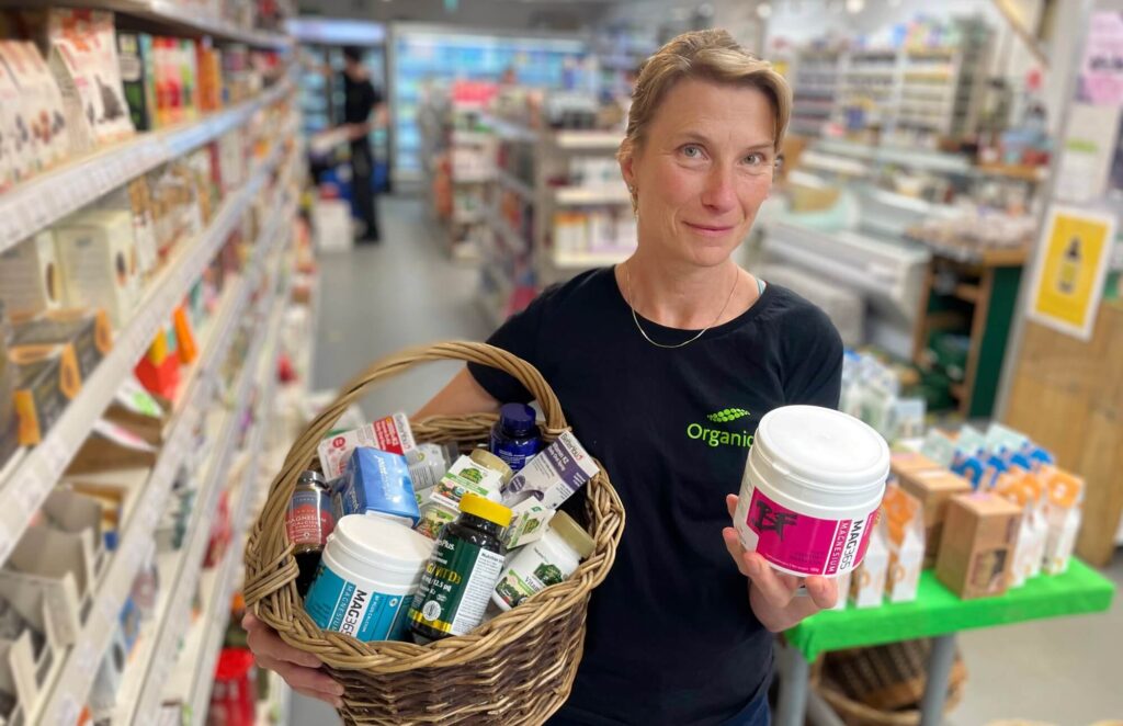 Fleur standing in Organico with a basket filled with bone health supplements. 