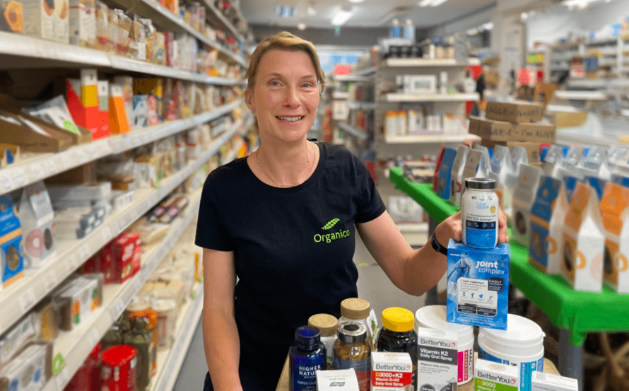 Fleur standing in Organico shop with a selection of bone health supplements. 